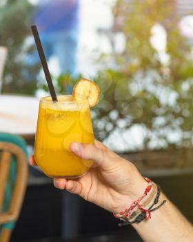 Man holding orange juice at restaurant