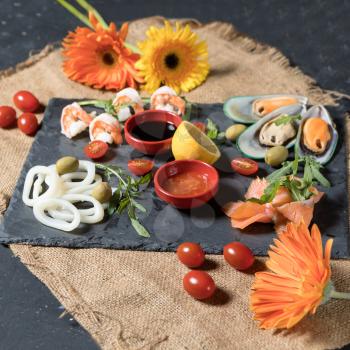 Fresh fish and seafood arrangement on black stone background