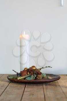 white candle decoration in a wooden bowl on a table