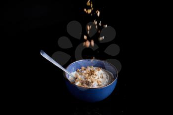 a blue bowl filled with yogurt on a black background