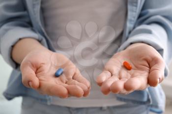 Young woman holding different pills, closeup�