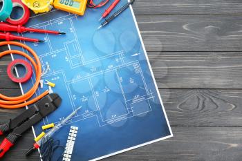 Flat lay composition with electrical tools and house plan on wooden background�