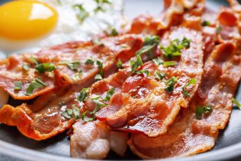Tasty bacon on frying pan, closeup�