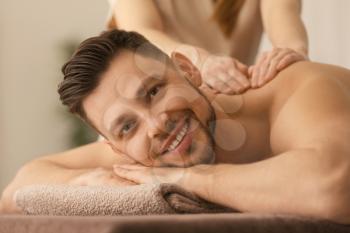 Young man receiving massage at spa salon�