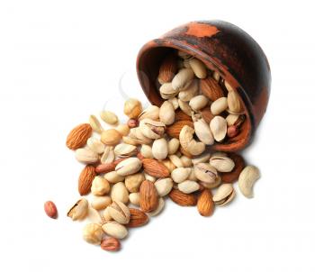 Overturned bowl with scattered nuts on white background�
