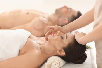 Happy young couple having massage in spa salon�