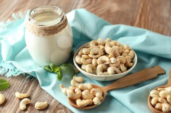 Composition with tasty cashew nuts on wooden background�