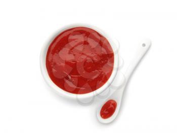 Bowl and spoon with red sauce on white background�