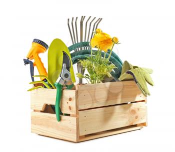 Wooden crate with gardening tools and plant on white background�