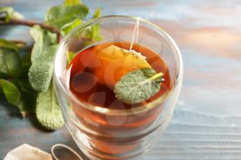 Brewing of hot tea with mint in cup on table�