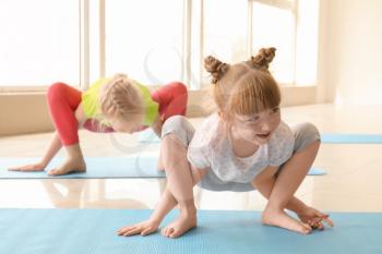 Little children practicing yoga indoors�