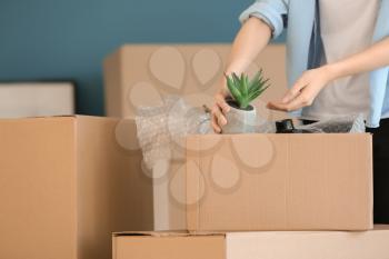 Woman packing carton box indoors. Moving house concept�