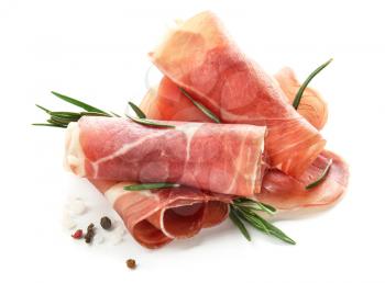Tasty prosciutto slices with rosemary and spices on white background�