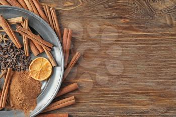 Composition with cinnamon sticks on wooden background�