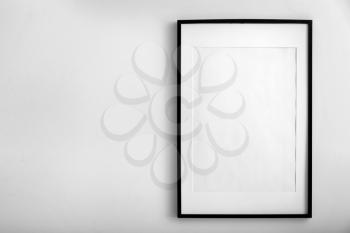Blank photo frame hanging on white wall�