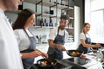 Young people during cooking classes in restaurant kitchen�