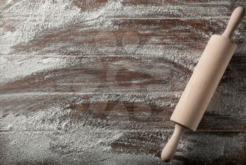 Scattered flour with rolling pin on wooden background�