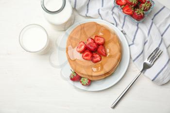 Composition with delicious pancakes, honey and strawberries on wooden table�