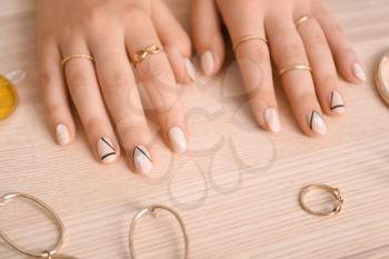 Female hands with stylish manicure and accessories on wooden background�