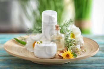 Composition with natural cosmetics and chamomile flowers on wooden table�