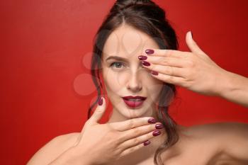 Beautiful young woman with professional manicure on color background�
