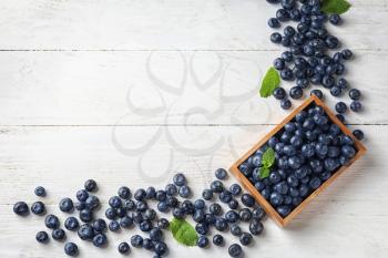Crate with ripe blueberries on wooden table�