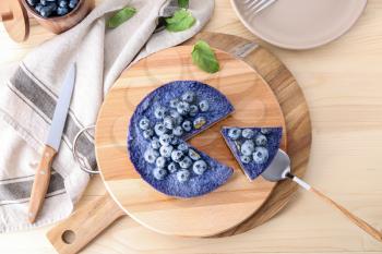 Tasty cheesecake with blueberries on wooden table�