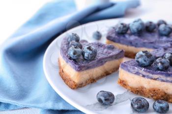 Tasty cheesecake with blueberries on plate, closeup�