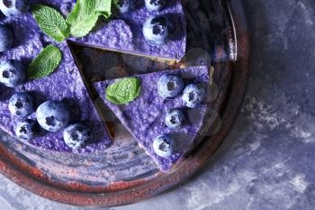 Plate with tasty blueberry cheesecake on dark table, closeup�