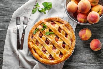 Delicious peach pie on wooden table�