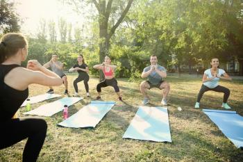 Group of sporty people training in park�