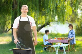 Man cooking delicious vegetables on barbecue grill outdoors�