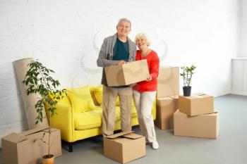 Mature couple with boxes after moving into new house�