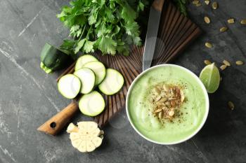 Tasty zucchini soup with pumpkin seeds in bowl on dark table�