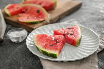 Plate with slices of watermelon on grunge background�