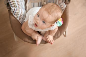 Cute baby in rocker looking at mother at home�