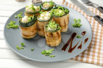 Tasty zucchini rolls with cheese on plate�