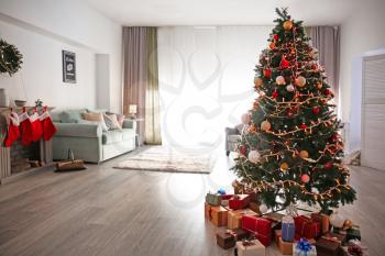 Beautiful decorated Christmas tree in cozy living room 