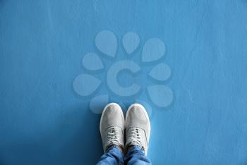 Legs of man in casual shoes on color background�