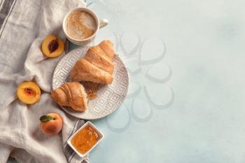 Plate and wooden board with tasty croissants on light table�
