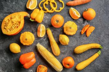 Flat lay composition with various vegetables and citrus fruits on dark background�