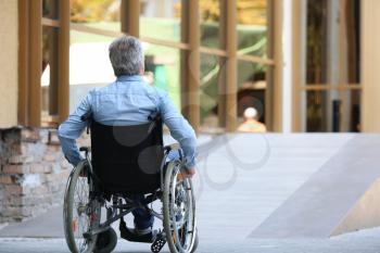 Senior man in wheelchair near ramp outdoors�