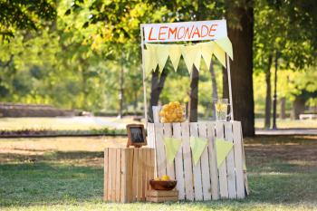 Wooden lemonade stand in park on sunny summer day�