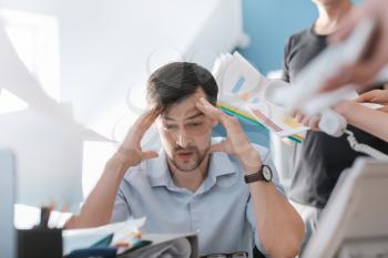 Stressed businessman with a lot of work in office�