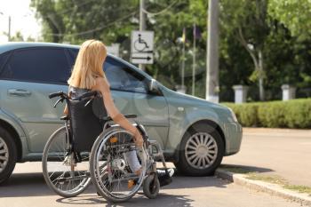 Woman in wheelchair next to her car�