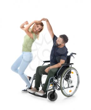Man in wheelchair with beautiful woman dancing on white background�