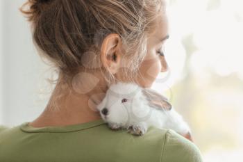 Beautiful young woman with cute rabbit at home�