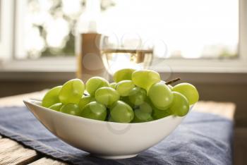 Bowl with sweet grapes on table�