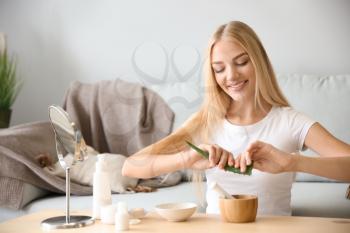 Young woman making healthy facial mask with aloe vera extract at home�