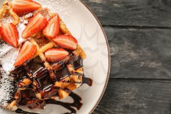 Sweet fresh waffles with chocolate and cut strawberry on plate�